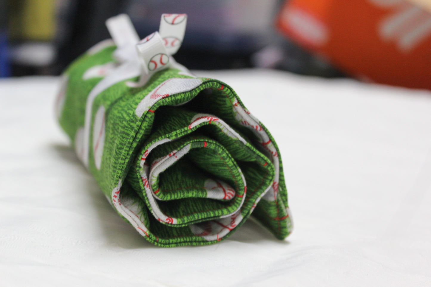 Baseballs on grass utensil roll-up